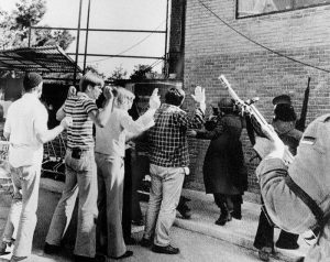 Armed Iranian rebels search Americans who were living in the U.S. Embassy compound in Teheran, Feb., 14, 1979.  During the takeover of the embassy this group was taken from their living quarters, brought into the courtyard and searched. Later they were taken to another building while the attackers occupied the compound. (AP Photo)